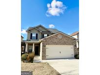 Charming two-story home boasts a brick facade, two-car garage, and well-maintained lawn at 6255 Hickory Lane Cir, Union City, GA 30291