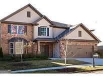 Two-story brick home with attached garage and landscaping at 1124 Pebble Creek Ln, Locust Grove, GA 30248