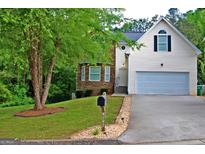 Charming two-story home featuring stone accents, a well-manicured lawn, and an attached two car garage at 4197 Arnolds Mill Opas, Douglasville, GA 30135