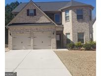 Charming brick home featuring a two-car garage and well-manicured landscaping at 12226 Flannery Ln, Hampton, GA 30228