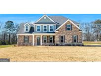 Two story house with brick and siding exterior, large windows and a grassy yard at 172 Austin Dr, Mcdonough, GA 30252
