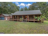 Charming log cabin home with a spacious front porch and detached garage at 184 Elm St, Covington, GA 30014