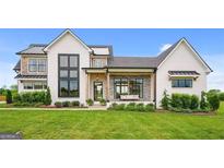 Stunning two-story farmhouse with white exterior, stone accents, and a covered porch at 0 Matteo Way # 16, Fayetteville, GA 30215