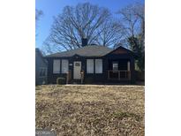Charming renovated home featuring dark exterior, modern railing, and a well-maintained lawn at 845 Metropolitan Sw Pkwy, Atlanta, GA 30310