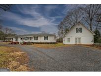 Charming home with a spacious gravel driveway and white exterior at 12178 Brown Bridge Rd, Covington, GA 30016