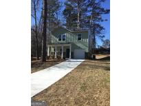 Two-story house with green siding, white columns, and a driveway at 9168 Carr Cir, Covington, GA 30014