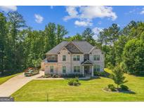 Beautiful two-story brick home featuring an attached three-car garage and professionally landscaped front yard at 4051 Rotterdam Pass, Hampton, GA 30228