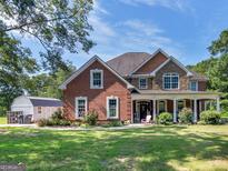 Brick house with stone accents, a large front porch, and landscaping at 10 Toscanno Dr, Covington, GA 30014