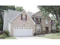Brick house with a two-car garage and landscaped lawn at 4768 Redbranch Rd, Decatur, GA 30035