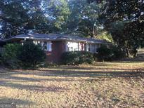 Brick ranch house with mature trees and a large yard at 1810 Highway 138 E, Stockbridge, GA 30281