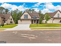Two-story house with a neutral color palette, three car garage, and a nicely landscaped yard at 206 Regester Way # 44, Peachtree City, GA 30269
