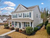 Two-story house with gray siding, a front porch, and landscaping at 300 South Village Sq, Canton, GA 30115