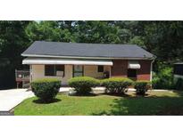Quaint, one-story bungalow with a red brick accent and well-manicured front yard at 1551 Ferno Nw Dr, Atlanta, GA 30318