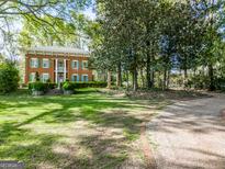 Brick two-story home with manicured lawn and long driveway at 3115 Pennington Sw St, Covington, GA 30014