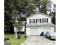 Two-story house with a two-car garage and a well-maintained lawn at 6941 Cedar Hill Ct, Riverdale, GA 30296