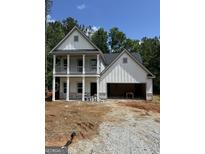Two-story home featuring a two-car garage and a charming porch at 115 Yancey Rd, Covington, GA 30014
