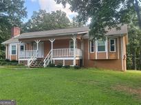Ranch style home with large front porch and expansive lawn at 216 Rivers Rd, Fayetteville, GA 30214