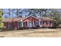 Brick ranch house with red shutters, white columns, and a spacious yard at 2760 The Fontainebleau Sw, Atlanta, GA 30331