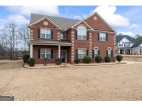 Brick two-story house with landscaping and a large front yard at 801 Carnegie Ct, Locust Grove, GA 30248