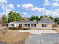 Ranch-style home with large driveway and mature landscaping at 424 N Green Cir, Mcdonough, GA 30252