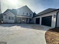 Two-story house with white siding, black accents, and a three-car garage at 145 Dockside Dr # 396, Fayetteville, GA 30215