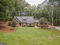 Brick house with gray roof, large yard, and driveway at 107 Rolling Green, Peachtree City, GA 30269