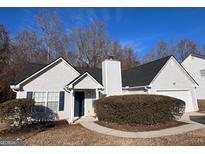 White house with dark grey roof,attached garage, and manicured shrubbery at 190 Wynfield Dr, Covington, GA 30016