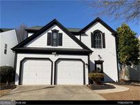 Two-story house with white siding, black accents, and a two-car garage at 2587 Alvecot Se Cir, Atlanta, GA 30339