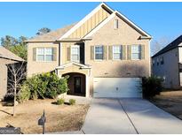 Two-story brick home with a well-manicured lawn, an attached garage, and a covered front entry at 5150 Amberland Sq, Atlanta, GA 30349