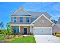 Two-story brick home with a large front yard and attached two-car garage at 303 Roundwood Way, Peachtree City, GA 30269