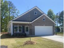 Charming single-Gathering home with a two-car garage, brick facade, and inviting front lawn at 1467 Trellis Court (Lot 5), Hampton, GA 30228