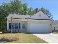 Charming single-story home with a white brick facade, manicured lawn, and attached two-car garage at 1479 Trellis Court (Lot 3), Hampton, GA 30228