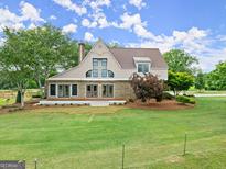 Brick home with a metal roof, deck, and landscaped yard at 241 Hosannah Rd, Locust Grove, GA 30248