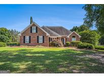 Charming brick home with lush green lawn and mature landscaping at 600 English Ct, Mcdonough, GA 30252