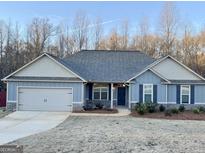 Newly constructed home with gray siding, stone accents, and a two-car garage at 504 Wylderose Ln, Locust Grove, GA 30248