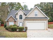 Two-story house with stone accents and a two-car garage at 308 Royal Crescent Way, Stockbridge, GA 30281