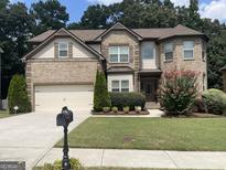 Brick house with two-car garage and landscaped lawn at 1830 Alder Tree Way, Dacula, GA 30019