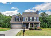 Two-story house with blue siding, gray roof, and a two-car garage at 275 Bramble Bush Trl, Covington, GA 30014