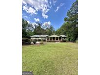 Ranch style home with brick facade, covered porch, and spacious lawn at 4020 Grady Smith Rd, Loganville, GA 30052