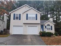 Two-story house with beige siding, two-car garage, and a landscaped yard at 5738 Antelope Trl, Atlanta, GA 30349