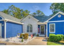 Charming home featuring a white brick facade, blue siding, and a welcoming front entrance adorned with seasonal decor at 2037 Emily Dr, Social Circle, GA 30025