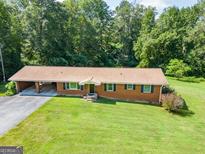 Ranch-style home with brick facade, car port, and inviting curb appeal at 677 Gum Creek Rd, Oxford, GA 30054