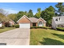 Brick ranch home with attached garage and landscaped lawn at 1152 Strath Clyde Way, Mcdonough, GA 30253