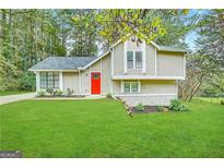 Two-story house with red door, light beige siding, and green lawn at 3951 Wabash Ln, Ellenwood, GA 30294