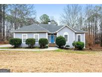 Gray house with blue door, stone steps, and landscaping at 123 Line Creek Way, Sharpsburg, GA 30277