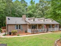 Brick ranch house with a wraparound porch and landscaped yard at 930 Singley Dr, Locust Grove, GA 30248