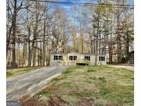 Charming single-story home with neutral siding, black shutters and inviting front porch situated on a treed lot at 58 Pinewood Dr, Carrollton, GA 30116