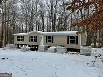 Newly constructed mobile home on wooded lot; snow on the ground at 58 Pinewood Dr, Carrollton, GA 30116