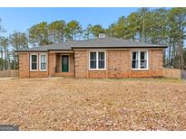 Brick ranch house with a green door and mature trees at 206 Sandown Drive, Peachtree City, GA 30269