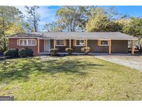 Newly renovated ranch home with brick and gray siding, showcasing a landscaped lawn at 1091 Pine St, Conyers, GA 30012